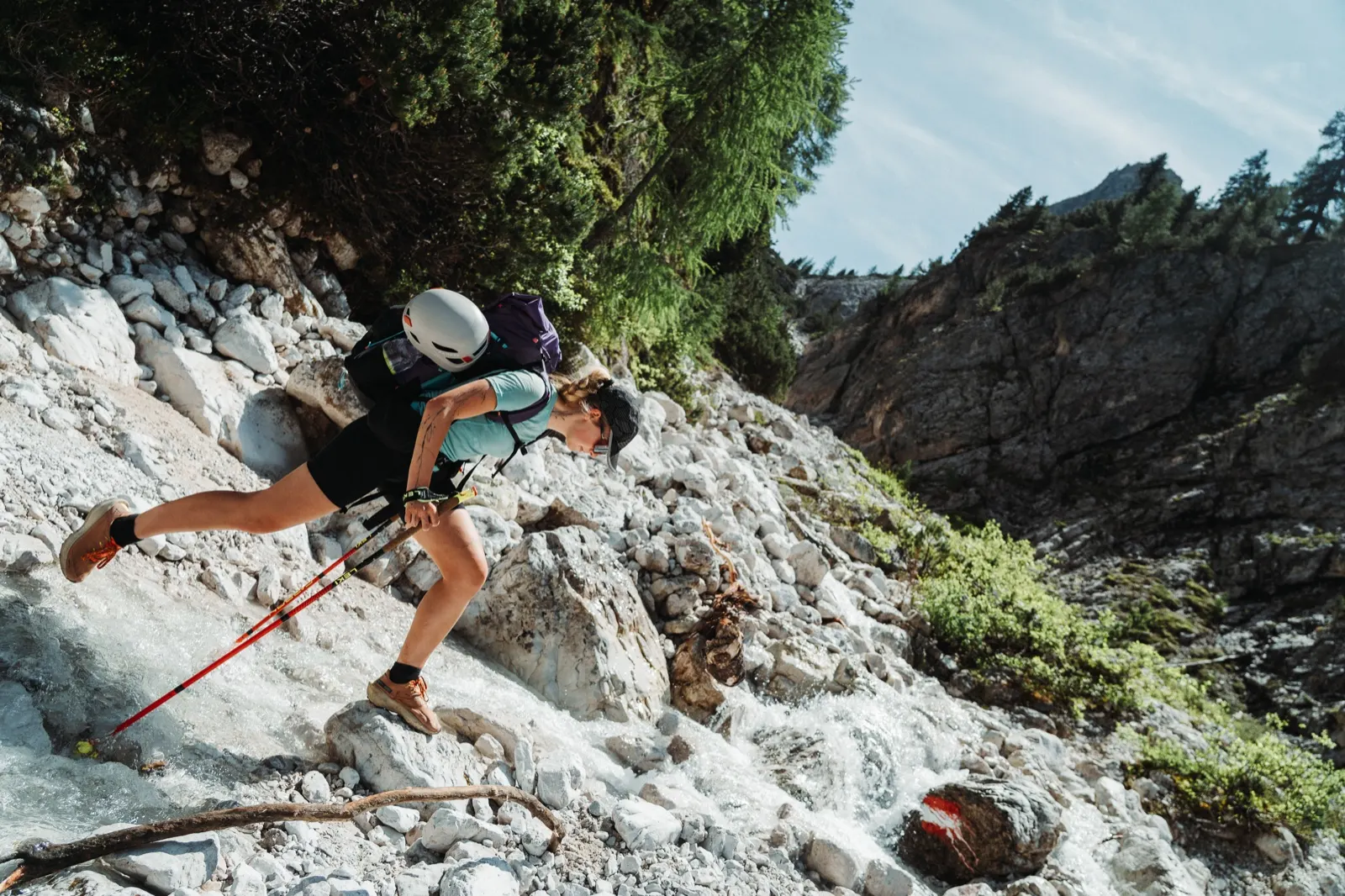 Hiker crossing a chain section in a rocky gully
