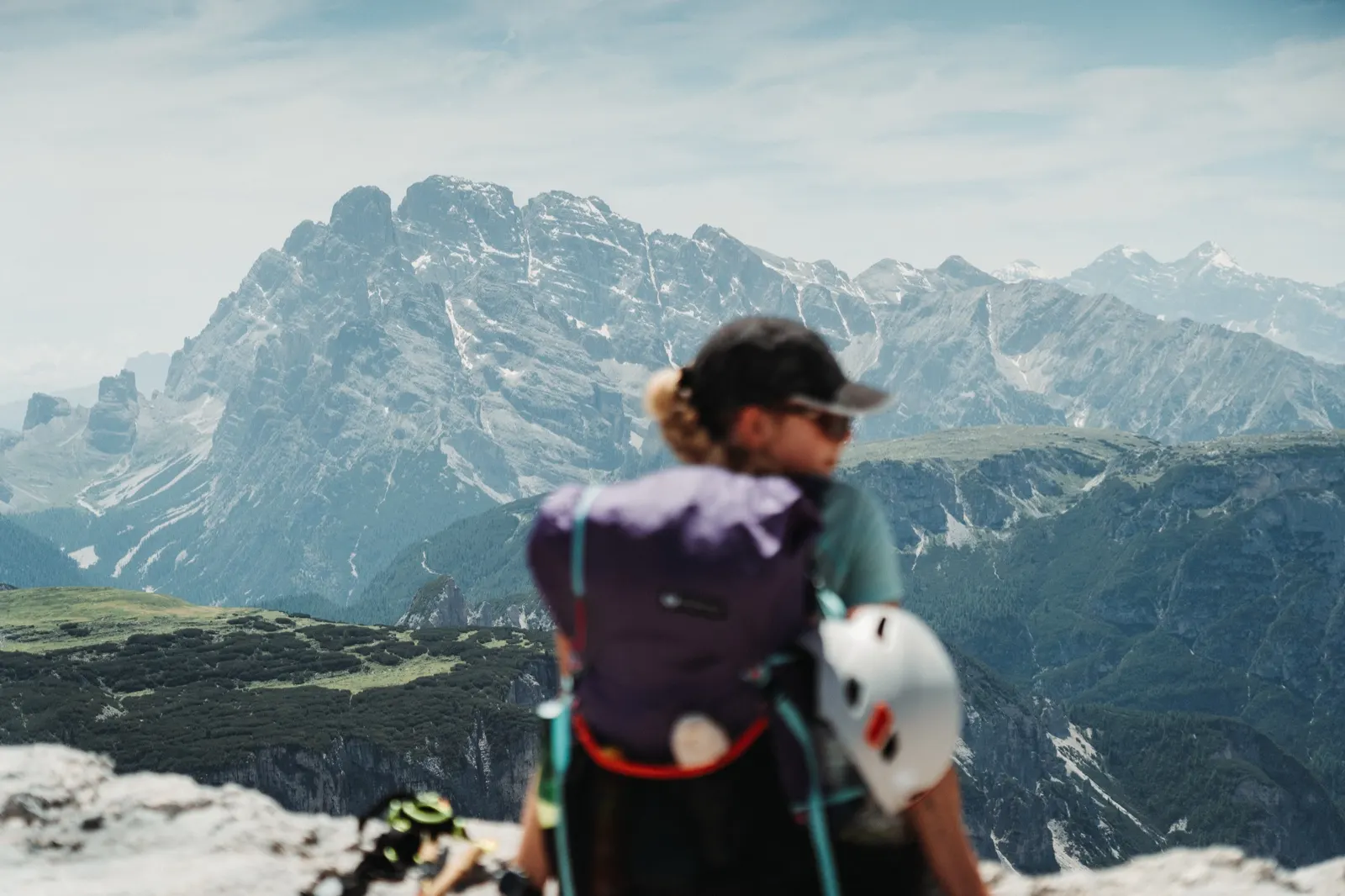 Hiker wearing a via ferrata set admires the view of the Dolomites