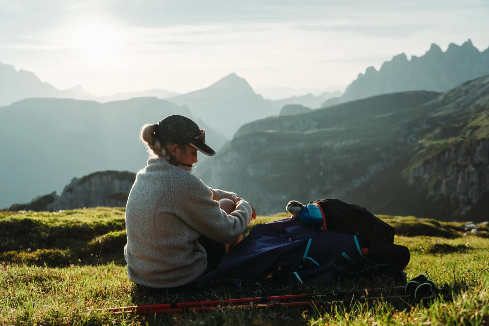 Resting on a sleeping mat with a view of the setting sun and mountain silhouettes