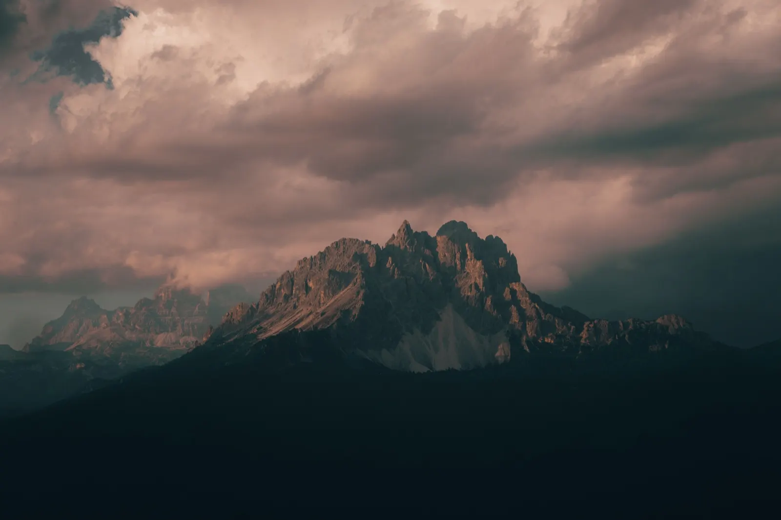 A view of the dramatic Dolomite scenery under a cloudy sky at sunset