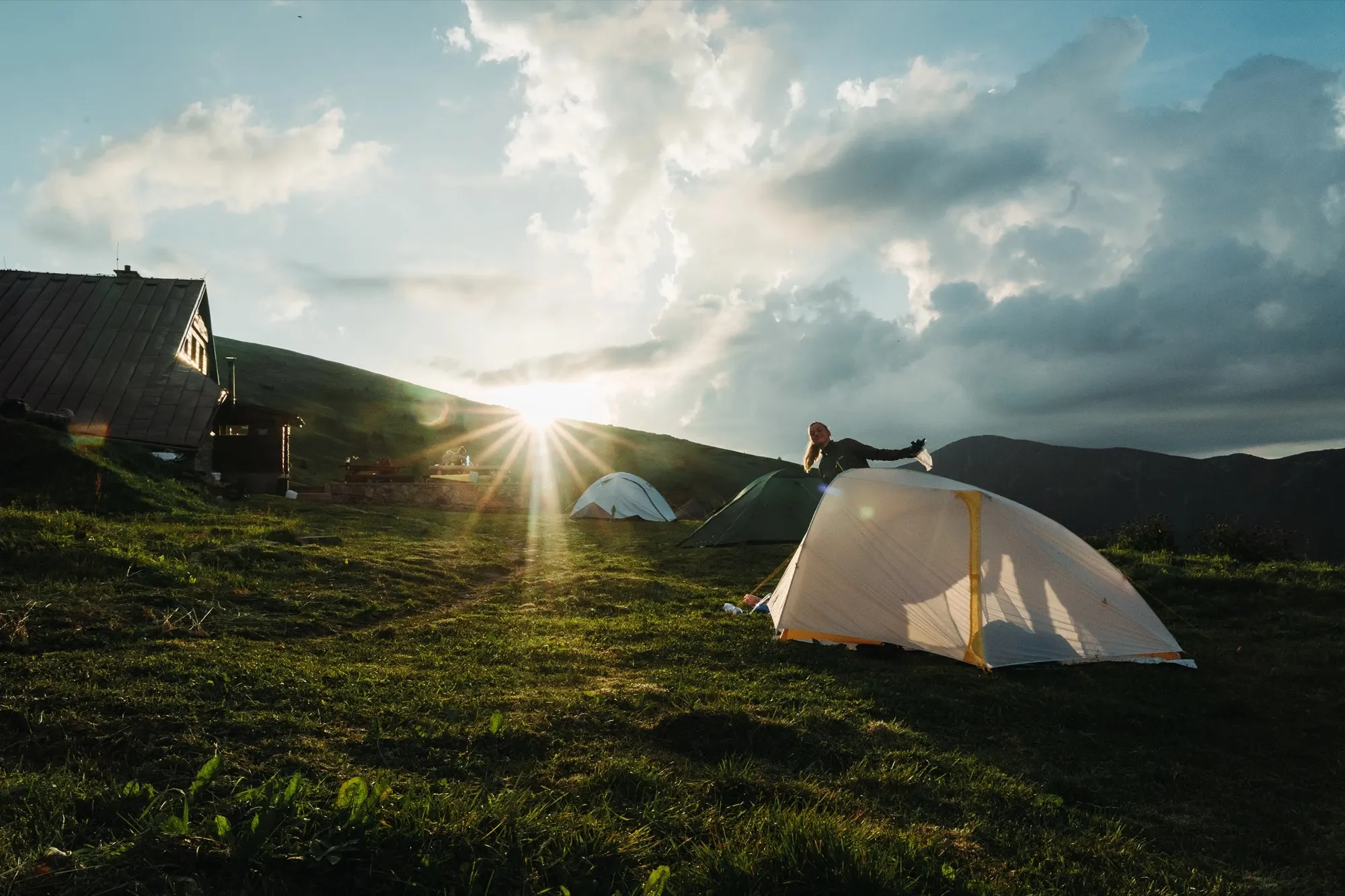 Tiger Wall UL2 on a grassy hill under a sunburst between clouds