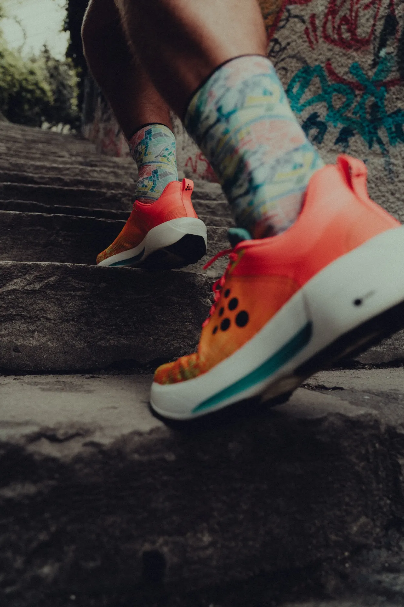 Orange Craft Nordlite Ultra 2 on a runner's foot, resting on a stone ledge