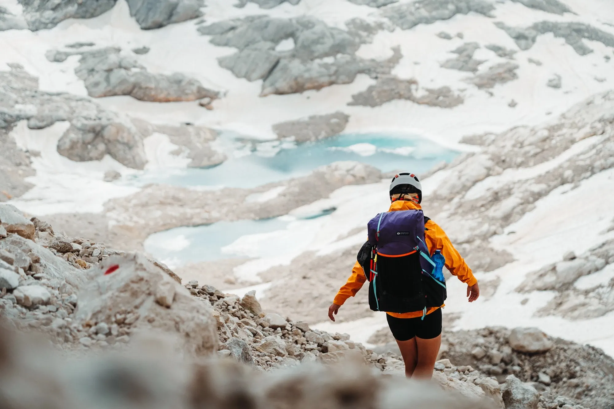 Turista s batohem Gossamer Gear Gorilla 50 přechází skalnatý horský terén