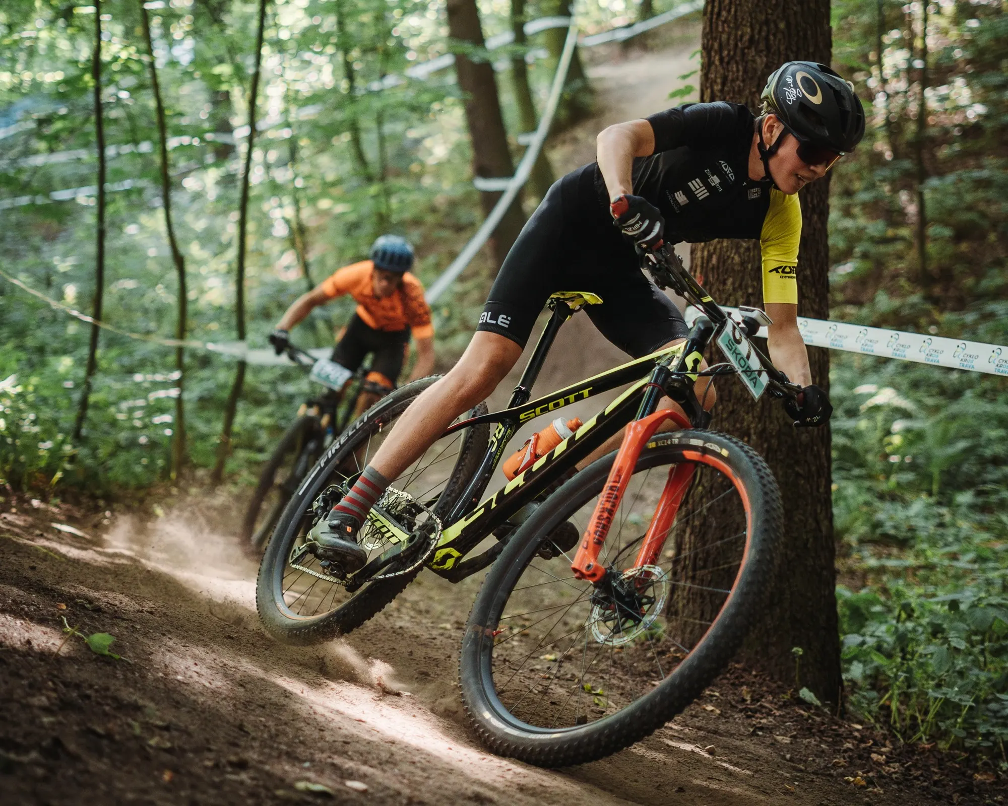 Horský cyklista ostře zatáčí v lesní klopené zatáčce na finále MTB Cupu v Ostravě
