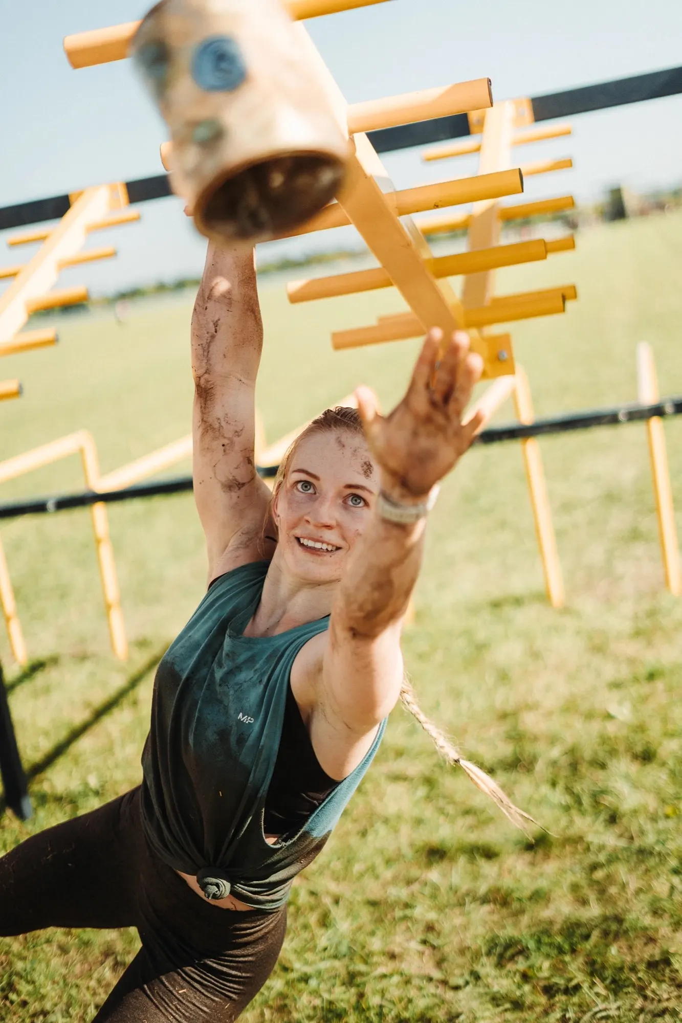 Smiling competitor reaching up under yellow marker tape