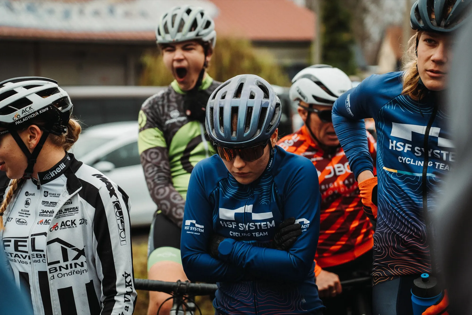 Crowded start line with riders in team jackets